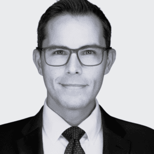 Professional man in business attire with glasses.