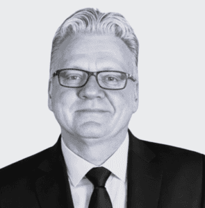 Senior professional in business attire with glasses, representing expertise and trustworthiness.