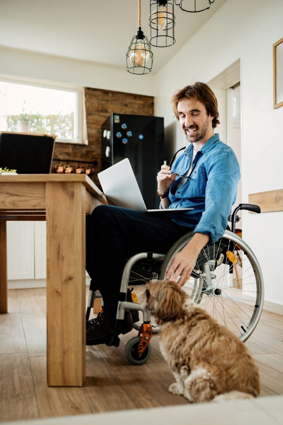 Accessible workspace with man in wheelchair and dog, highlighting benefits of inclusive environments.
