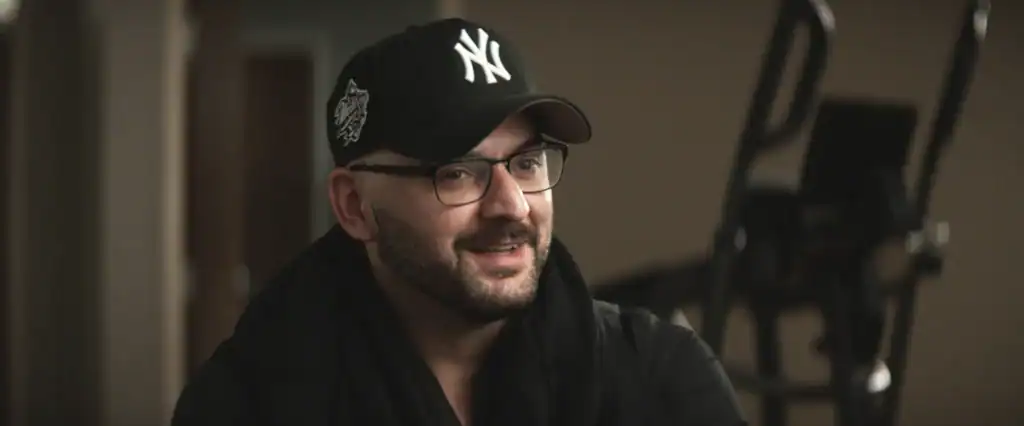 Man with glasses and baseball cap smiling indoors at WalkPort station.