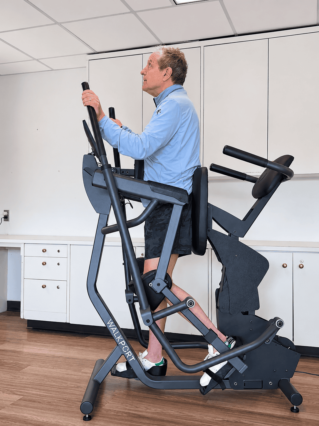 Supported walk station in use during gait training with patient standing and holding handles.