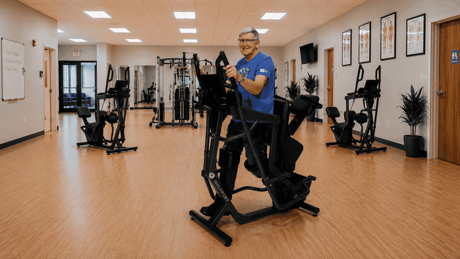 A man standing and walking in the WalkPort Supported Walk Station at a rehab facility